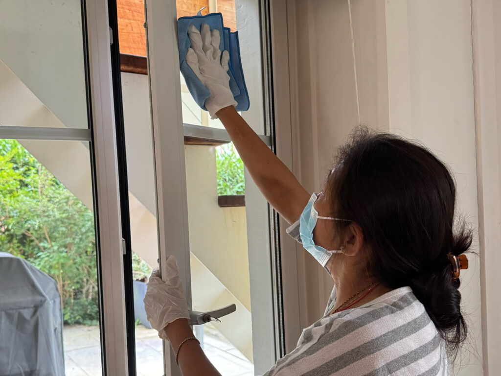 Frau, die eine Fensterscheibe putzt